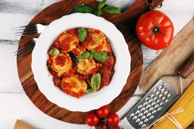 Mantı domates soslu parmesan peyniri ve bas ile süslenmiş