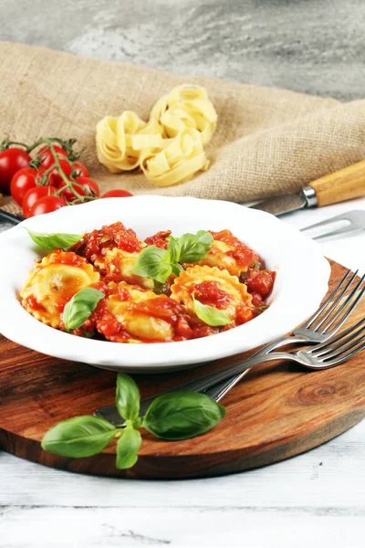 Mantı domates soslu parmesan peyniri ve bas ile süslenmiş