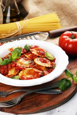 Mantı domates soslu parmesan peyniri ve bas ile süslenmiş