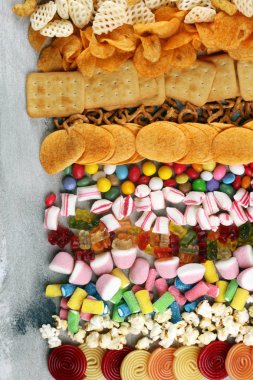 Tuzlu atıştırmalıklar. Tabl üzerinde kraker, cips, kraker ve şeker tatlılar