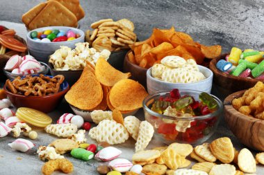 Tuzlu atıştırmalıklar. Tabl üzerinde kraker, cips, kraker ve şeker tatlılar