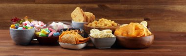 Tuzlu atıştırmalıklar. Tabl üzerinde kraker, cips, kraker ve şeker tatlılar