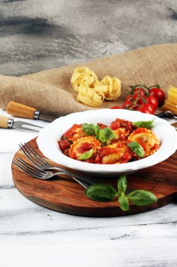 Mantı domates soslu parmesan peyniri ve bas ile süslenmiş