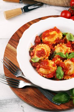 Mantı domates soslu parmesan peyniri ve bas ile süslenmiş