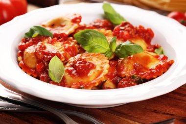 Mantı domates soslu parmesan peyniri ve bas ile süslenmiş