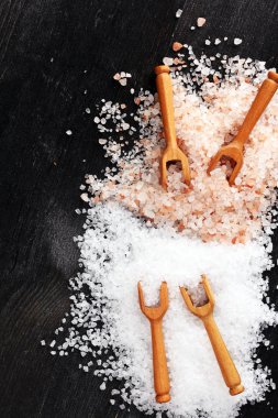 Kaşıkta deniz tuzu ve himalaya. Koyu backgr üzerinde tuz kristalleri