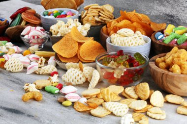 Tuzlu atıştırmalıklar. Tabl üzerinde kraker, cips, kraker ve şeker tatlılar