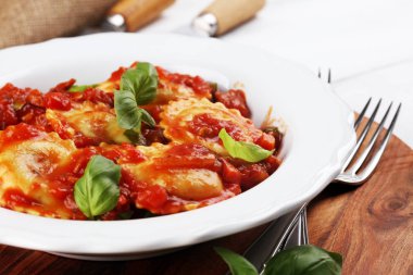 Mantı domates soslu parmesan peyniri ve bas ile süslenmiş