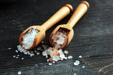 Kaşıkta deniz tuzu ve himalaya. Koyu backgr üzerinde tuz kristalleri