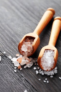 Kaşıkta deniz tuzu ve himalaya. Koyu backgr üzerinde tuz kristalleri