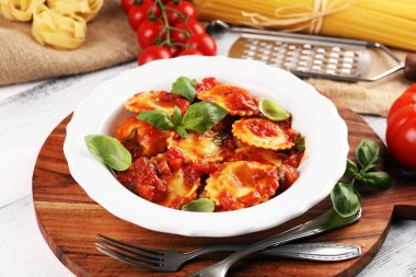 Mantı domates soslu parmesan peyniri ve bas ile süslenmiş