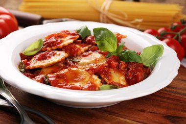 Mantı domates soslu parmesan peyniri ve bas ile süslenmiş