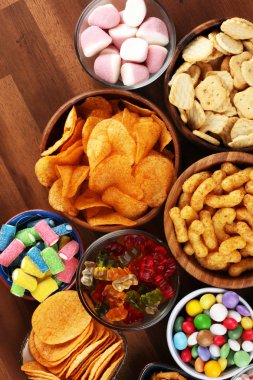 Tuzlu atıştırmalıklar. Tabl üzerinde kraker, cips, kraker ve şeker tatlılar