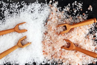 Kaşıkta deniz tuzu ve himalaya. Koyu backgr üzerinde tuz kristalleri