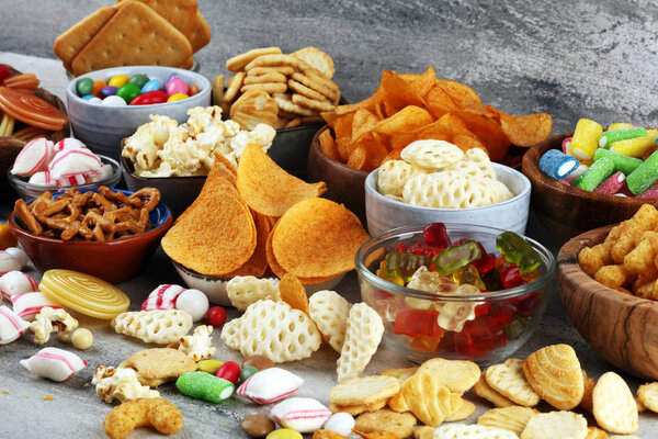 Salty snacks. Pretzels, chips, crackers and candy sweets on tabl