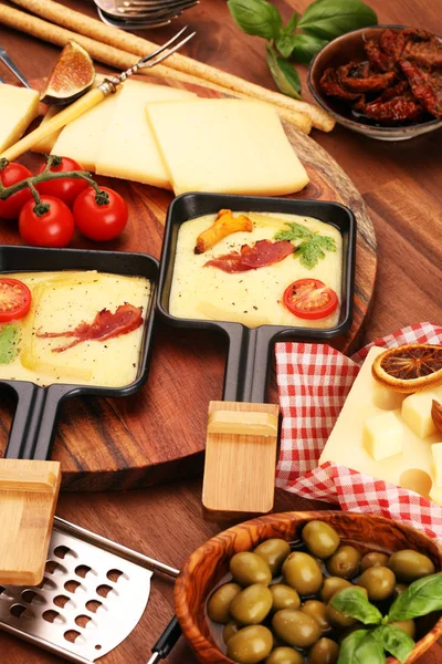 Delicioso queijo raclette tradicional suíço derretido em fervura em cubos — Fotografia de Stock