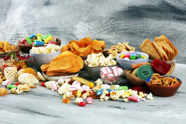 Tuzlu atıştırmalıklar. Tabl üzerinde kraker, cips, kraker ve şeker tatlılar — Stok fotoğraf