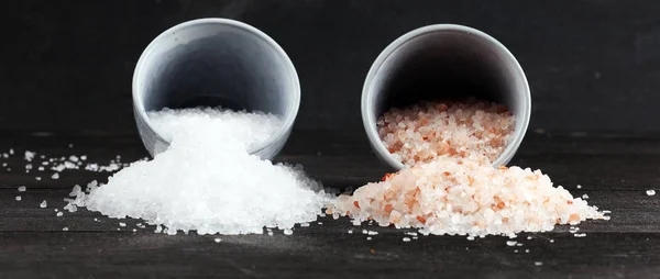 Sea salt and himalayan in bowl. Crystals of salt on dark backgro — Stock Photo, Image