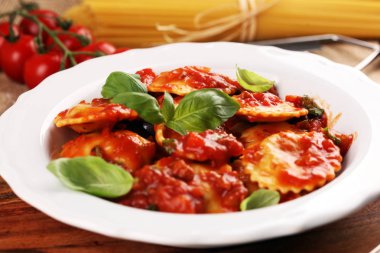 Mantı domates soslu parmesan peyniri ve bas ile süslenmiş