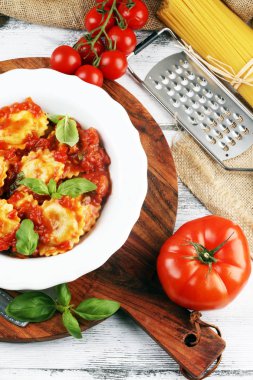 Mantı domates soslu parmesan peyniri ve bas ile süslenmiş