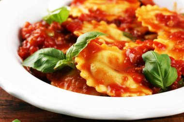 Mantı domates soslu parmesan peyniri ve bas ile süslenmiş