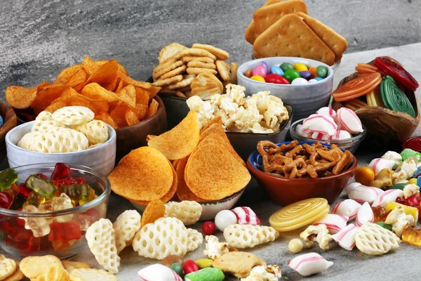 Salty snacks. Pretzels, chips, crackers and candy sweets on tabl — Stock Photo, Image