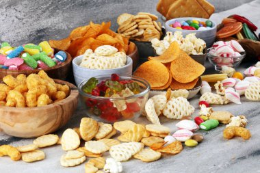 Tuzlu atıştırmalıklar. Tabl üzerinde kraker, cips, kraker ve şeker tatlılar