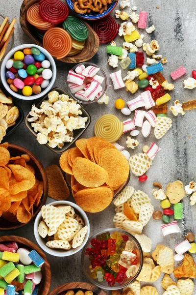 Salty snacks. Pretzels, chips, crackers and candy sweets on tabl — Stock Photo, Image