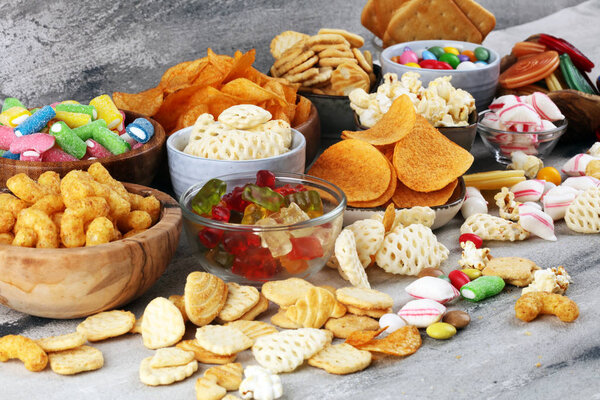 Salty snacks. Pretzels, chips, crackers and candy sweets on tabl