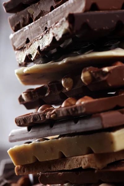 Barras de chocolate sobre un fondo rústico oscuro con torre de chocolate — Foto de Stock