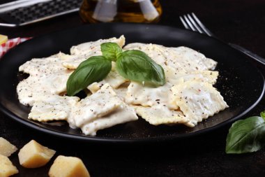 Parmesan peyniri ve fesleğen ile süslenmiş carbonara ile Ravioli 