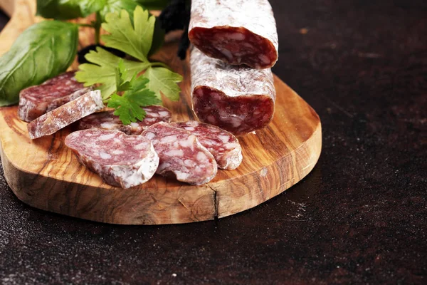 Salami geschnitten. dünn geschnittene Salami auf einer Holzstruktur auf dem Rücken — Stockfoto