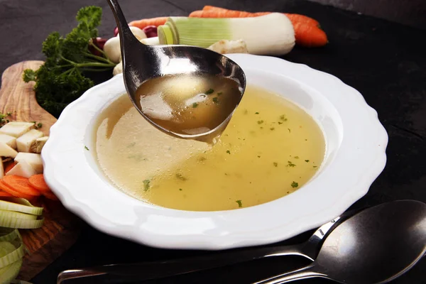 Caldo com cenouras, cebolas várias verduras frescas em um pote - c — Fotografia de Stock