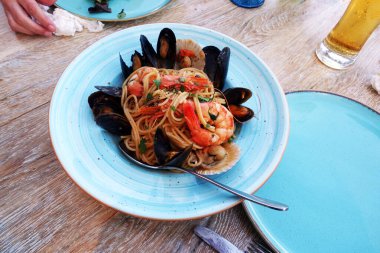 Kırsal bir masada bir restoranda deniz ürünleri makarnası.