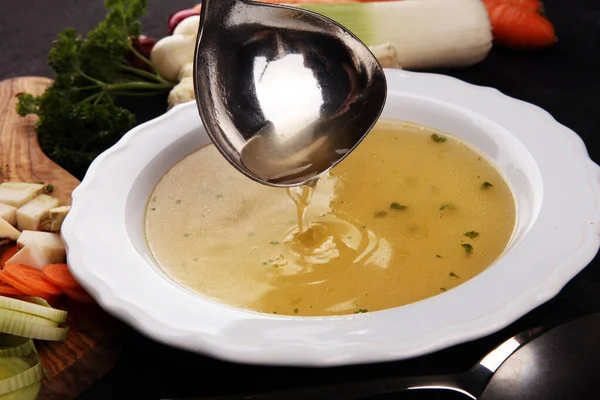Broth with carrots, onions various fresh vegetables in a pot - c — Stock Photo, Image