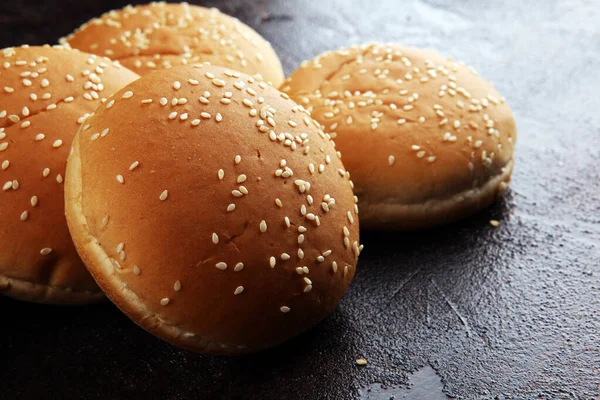 Fresh homemade burger buns with sesame on dark background — Stock Photo, Image