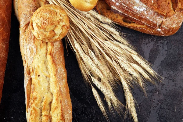 Verschillende soorten brood en broodjes aan boord van bovenaf. — Stockfoto