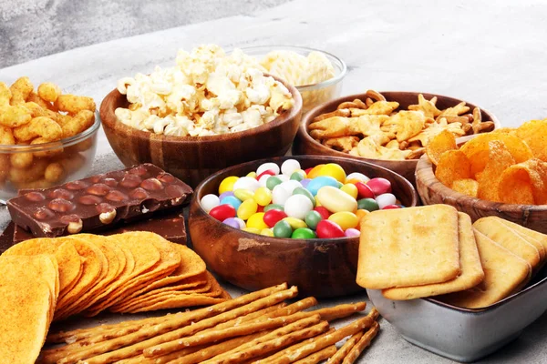 Zoute snacks. Pretzels, chips, crackers in houten kommen en cand — Stockfoto