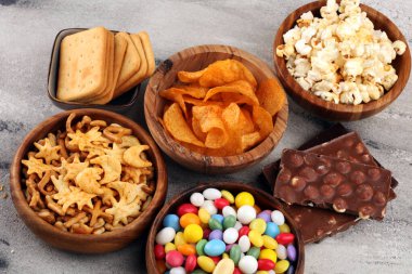 Tuzlu atıştırmalıklar. Kraker, cips, kraker, ahşap kaseler ve kraker.