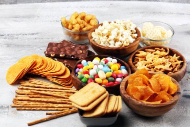 Tuzlu atıştırmalıklar. Kraker, cips, kraker, ahşap kaseler ve kraker.