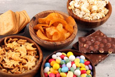 Tuzlu atıştırmalıklar. Kraker, cips, kraker, ahşap kaseler ve kraker.