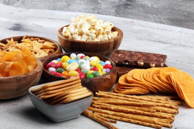 Tuzlu atıştırmalıklar. Kraker, cips, kraker, ahşap kaseler ve kraker.