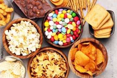 Tuzlu atıştırmalıklar. Kraker, cips, kraker, ahşap kaseler ve kraker.