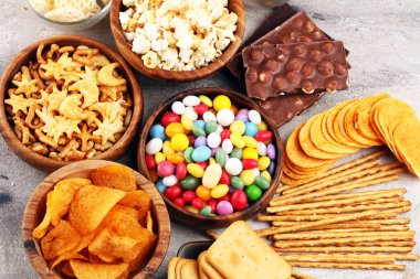 Tuzlu atıştırmalıklar. Kraker, cips, kraker, ahşap kaseler ve kraker.