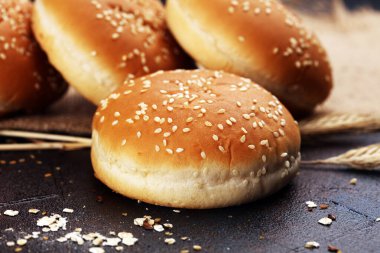 Koyu arkaplanda susamlı ev yapımı hamburger çörekleri.