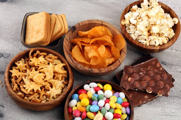 Spuntini salati. Pretzel, patatine fritte, cracker in ciotole e ciotole di legno — Foto Stock