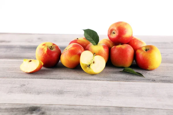 Pommes rouges mûres avec des feuilles sur fond en bois — Photo