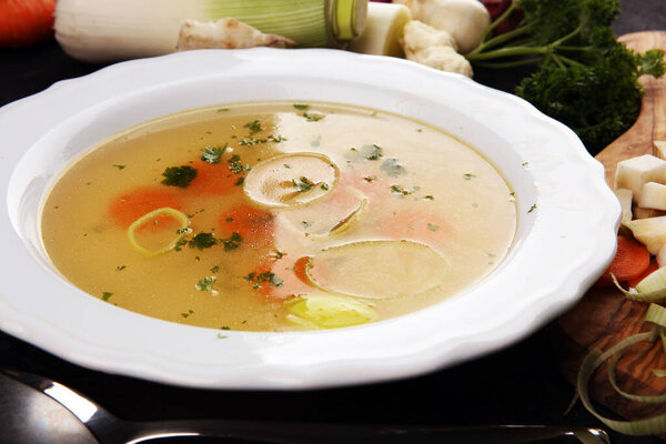 Broth with carrots, onions various fresh vegetables in a pot - c