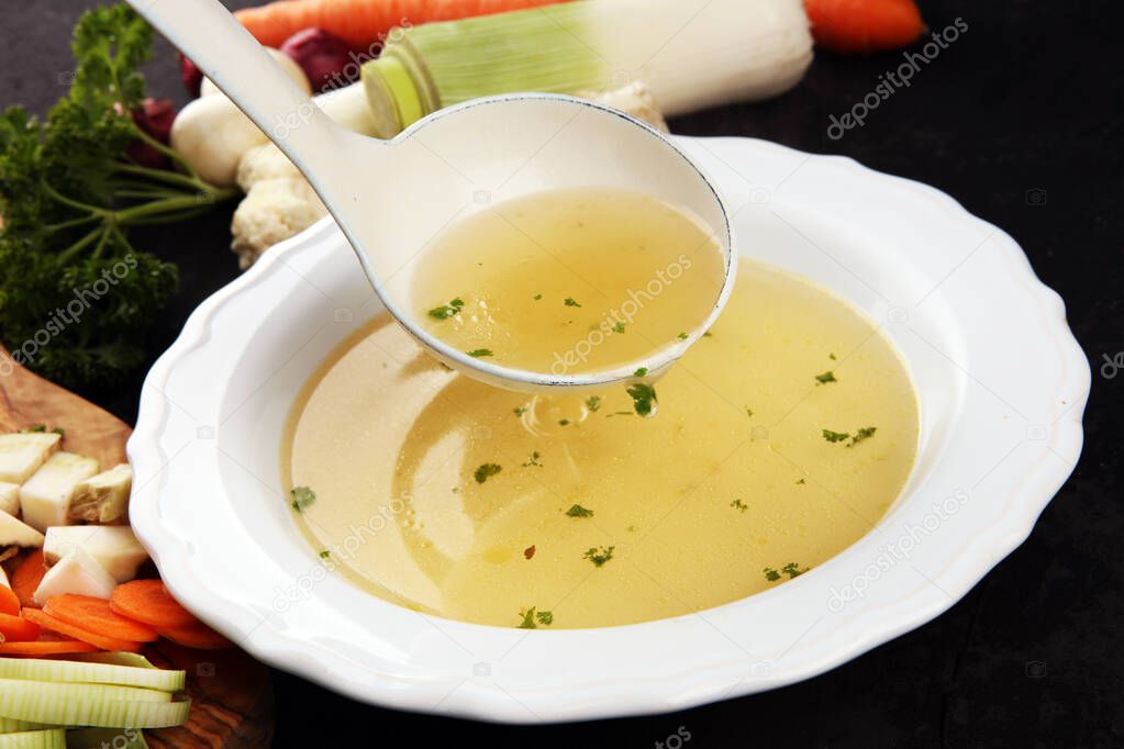 Broth with carrots, onions various fresh vegetables in a pot - c