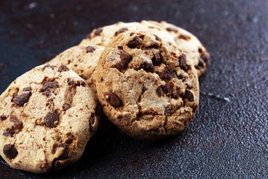 Tahta masanın üzerine çikolatalı kurabiyeler. Çikolatalı kurabiye o vurdu